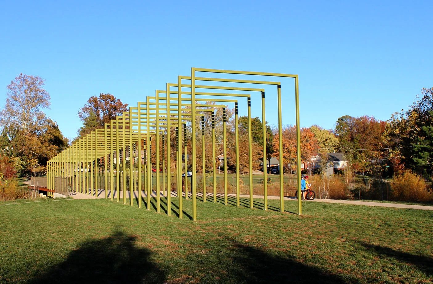 Evans Parkway Neighborhood Park in Wheaton — its signature yellow pergola on the green, framed by an autumn tree line