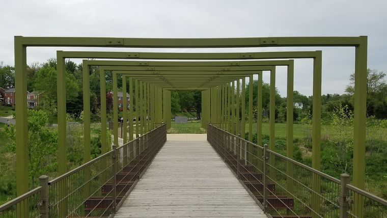 A boardwalk running beneath the park's yellow pergola arches