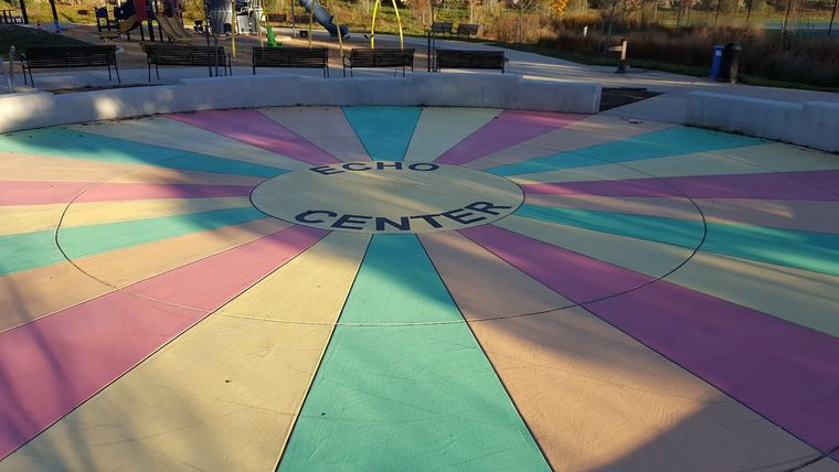 A concrete plaza painted in colorful radiating wedges, labeled Echo Center